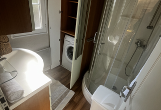 Badeværelse i Premium Mobile Home ved Campsite Les Franquettes, med brusekabine, vaskemaskine og vindue.
