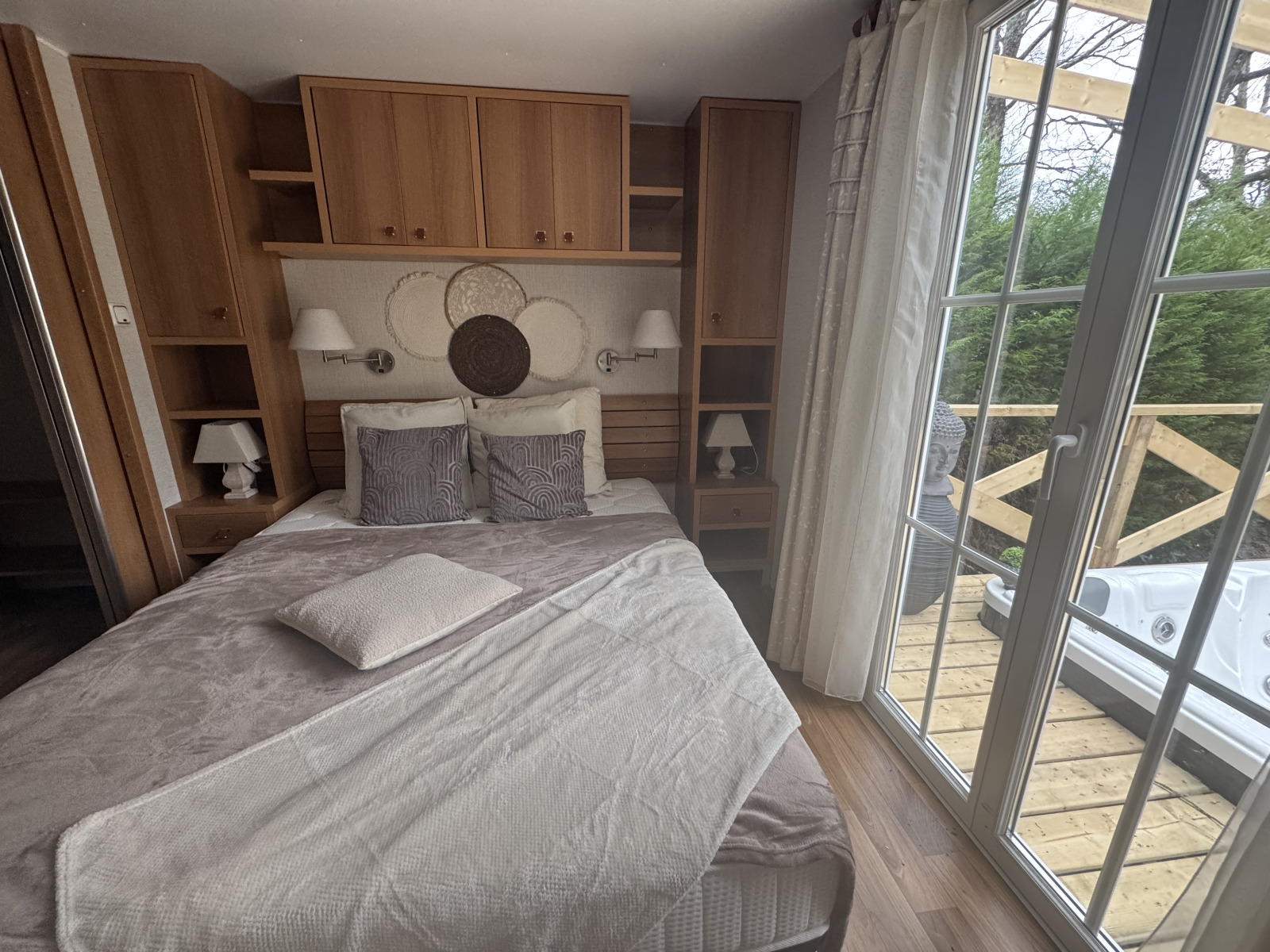 Premium stacaravan slaapkamer met tweepersoonsbed, houten kasten en terras met jacuzzi, Les Franquettes, Frankrijk.