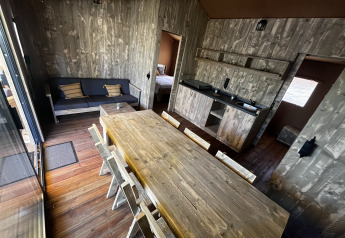 Vista interior de la tienda safari Luxury Lodge XXL en el camping Les Franquettes en Francia, con decoración rústica.