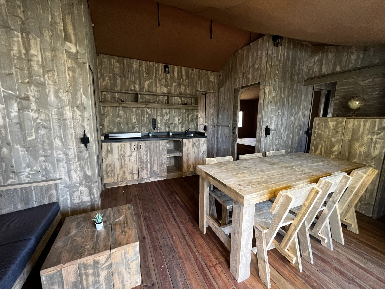 Interieur van de Luxury Lodge XXL safaritent op Camping Les Franquettes in Frankrijk met houten meubels.