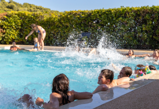 Bambini che giocano e spruzzano acqua nella piscina del campeggio Les Tamaris, Provenza-Alpi-Costa Azzurra, Francia.
