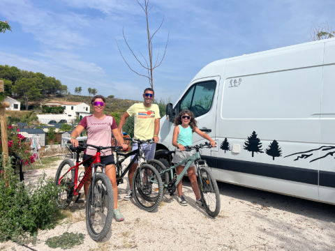 Family with bicycles in front of a white camper van at Campsite Les Tamaris, Provence-Alpes-Côte d’Azur, France.