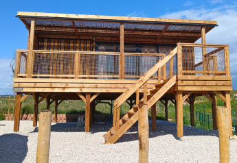 Premium chalet with hilly location, wooden construction raised on stilts with stairs and a terrace.
