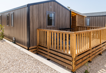 Chalet Premium Mobile Home en una zona con colinas, terraza de madera y exterior moderno al aire libre.