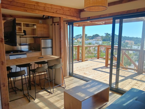 Binnenzicht van het Premium Chalet op Camping Les Tamaris in Frankrijk met keuken en houten terras.