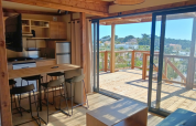 Interior view of the Premium Chalet at Campsite Les Tamaris in France with kitchen and wooden terrace.
