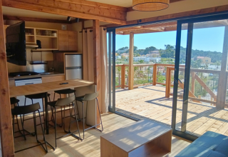 Binnenzicht van het Premium Chalet op Camping Les Tamaris in Frankrijk met keuken en houten terras.