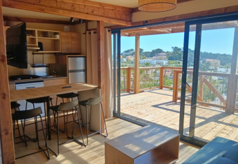 Vista interna del Premium Chalet al Campeggio Les Tamaris in Francia con cucina e terrazza in legno.