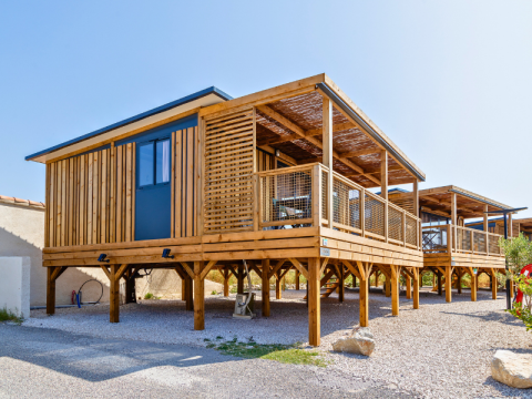 Modern Premium chalet op palen bij camping Les Tamaris in Frankrijk met grote houten veranda.