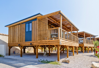 Modern Premium chalet op palen bij camping Les Tamaris in Frankrijk met grote houten veranda.