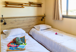 Premium chalet kamer bij Camping Les Tamaris in Frankrijk met twee enkele bedden en ruim raam.