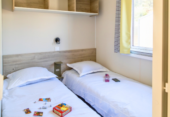 Dos camas individuales en una habitación luminosa y moderna del Premium mobile home en Campsite Les Tamaris, Francia.