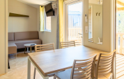 Interior view of Premium Mobile Home at Campsite Les Tamaris in France with dining table and sofa.