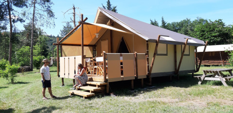 Two people in front of a safari tent called 'Jungle Lodge' at Campsite Ushuaïa Villages Le Viaduc in France.