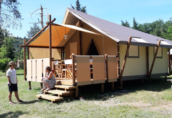 Two people in front of a safari tent called 'Jungle Lodge' at Campsite Ushuaïa Villages Le Viaduc in France.