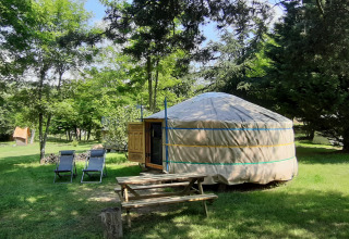 A traditional yurt with picnic table and loungers, set in green nature at Campsite Ushuaïa Villages Le Viaduc.
