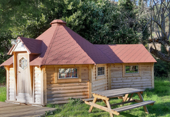 Finnish kota lodge at Campsite Ushuaïa Villages Le Viaduc, France, set among trees with a picnic table.