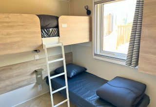 Camera con letto a castello e singolo nel Premium Mobile Home «Large» al Campeggio Les Tamaris, Francia.