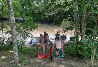 Bambini giocano su uno scivolo vicino alla spiaggia del fiume al campeggio Ushuaïa Villages Le Viaduc in Francia.