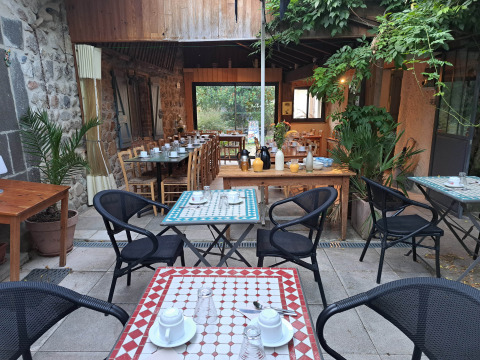 Zona pranzo all’aperto apparecchiata al campeggio Ushuaïa Villages Le Viaduc in Auvergne-Rhône-Alpes, Francia.