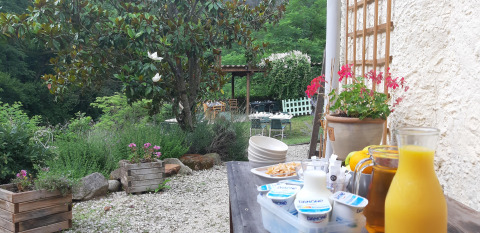 Outdoor breakfast with juice, yogurt, and flowers at Ushuaïa Villages Le Viaduc campsite in France.