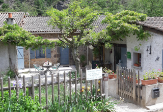 View of the reception area and patio at Ushuaïa Villages Le Viaduc campsite in Auvergne-Rhône-Alpes, France.