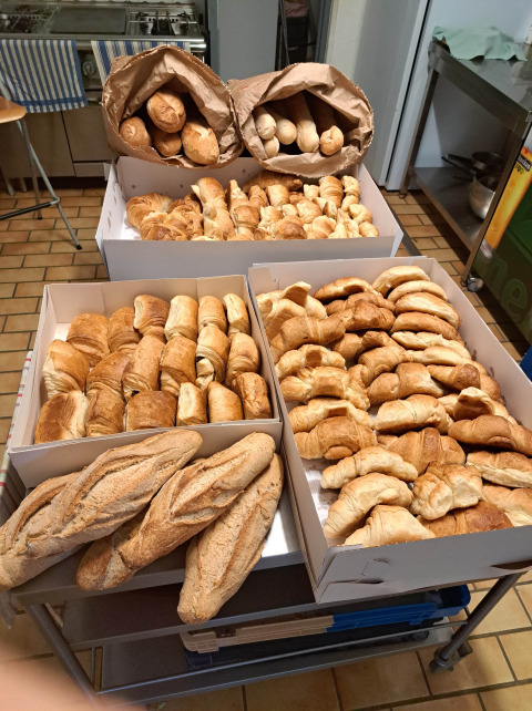 Pane fresco e croissant esposti su un tavolo al campeggio Ushuaïa Villages Le Viaduc in Francia.