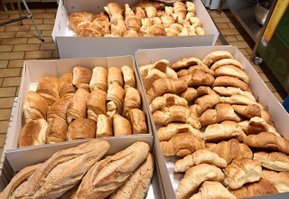 Freshly baked bread and croissants displayed on a table at Ushuaïa Villages Le Viaduc campsite in France.