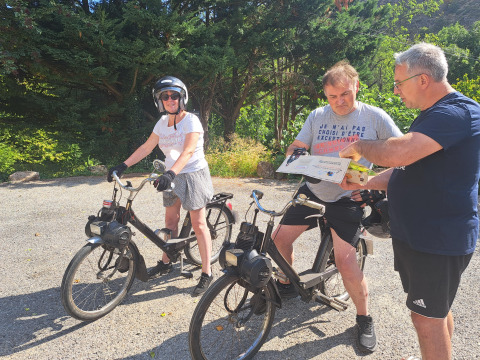 Due persone su biciclette d’epoca e una terza con una mappa godono il sole vicino ad Arlebosc, Francia.