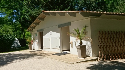 Modern restroom facility at Ushuaïa Villages Le Viaduc campsite, surrounded by trees and nature, France.