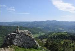 Vista di colline e antiche rovine in pietra al Campeggio Ushuaïa Villages Le Viaduc in Alvernia-Rodano-Alpi, Francia.