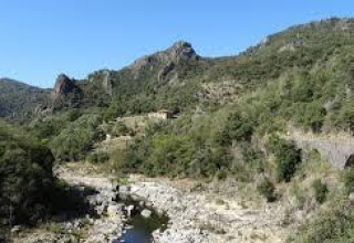 Scenic view of mountains, river and viaduct at Ushuaïa Villages Le Viaduc campsite in Auvergne-Rhône-Alpes, France.