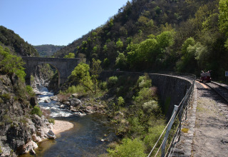 Scenic view of river, stone bridge and railway track near Ushuaïa Villages Le Viaduc holiday park.