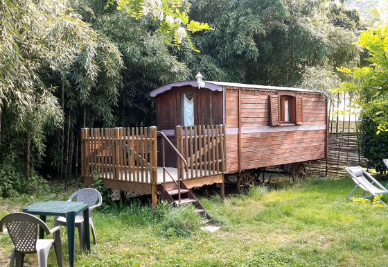 Piccola casa su ruote con veranda e mobili da giardino al campeggio Ushuaïa Villages Le Viaduc in Francia.