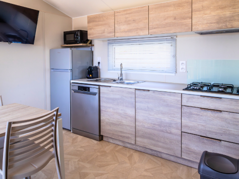 Cucina moderna della Premium Mobile Home presso il campeggio Les Tamaris, Francia, con mobili in legno.