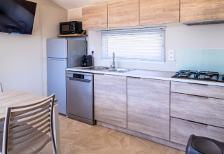 Cucina moderna della Premium Mobile Home presso il campeggio Les Tamaris, Francia, con mobili in legno.