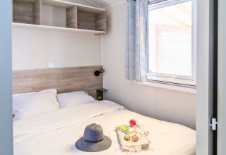 Camera da letto nel Premium Mobile Home al campeggio Les Tamaris, letto grande e finestra luminosa.