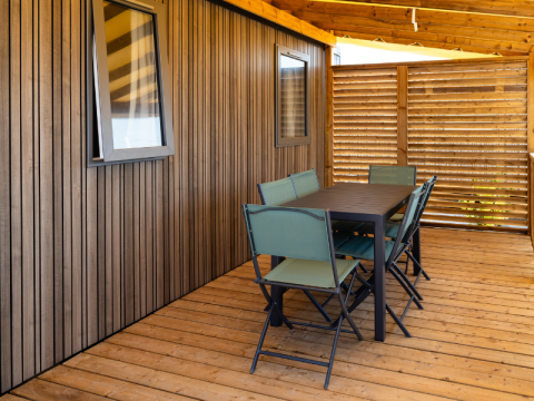 Terrazza in legno coperta con tavolo e sei sedie della Premium Mobile Home «Large Hilly location» a Les Tamaris.