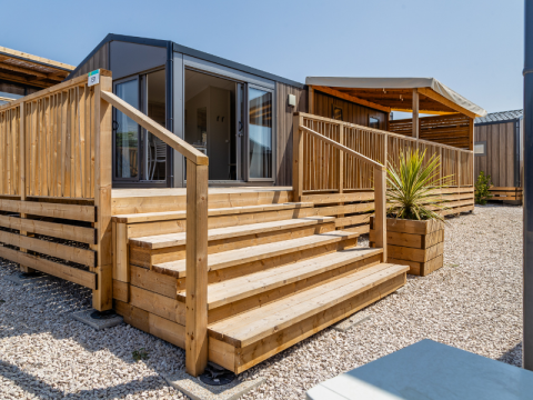 Scala in legno per il Premium Mobile Home 'Large Hilly location' al campeggio Les Tamaris, Francia.