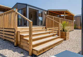 Scala in legno per il Premium Mobile Home 'Large Hilly location' al campeggio Les Tamaris, Francia.