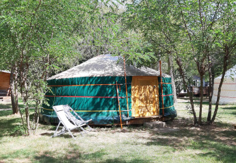 Tenda yurta al campeggio Ushuaïa Villages Le Viaduc in Francia, immersa tra alberi e area relax.