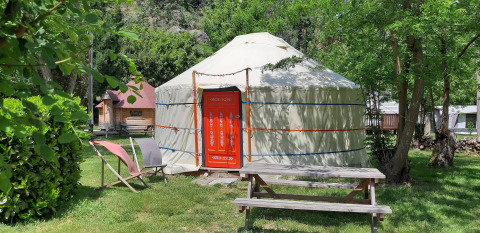 WOOD Yurt at Campsite Ushuaïa Villages Le Viaduc, France, with wooden picnic table and chairs outside.