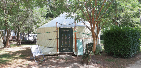 Traditionele yurt-tent op Campsite Ushuaïa Villages Le Viaduc in Frankrijk omringd door bomen.