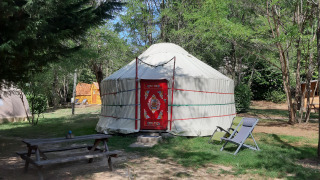 Afbeelding van een traditionele yurt op Campsite Ushuaïa Villages Le Viaduc in Frankrijk, omgeven door natuur.