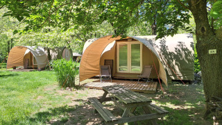 Safari tent Coco Sweet at Campsite Ushuaïa Villages Le Viaduc in France, surrounded by trees and greenery.