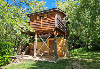Casa sull’albero al campeggio Ushuaïa Villages Le Viaduc in Francia, circondata da natura verde.