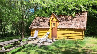 Die Magic hut, ein kleines gelbes Holzhaus auf dem Campingplatz Ushuaïa Villages Le Viaduc in Frankreich.