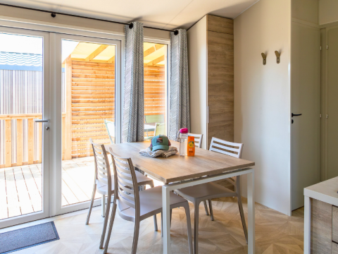 Lyst spiseområde i Premium Mobile Home på Campsite Les Tamaris med træterrasse og moderne møbler.