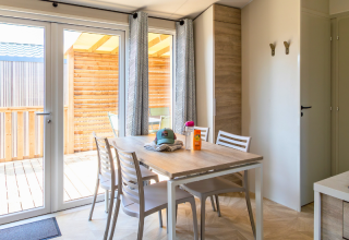 Lyst spiseområde i Premium Mobile Home på Campsite Les Tamaris med træterrasse og moderne møbler.