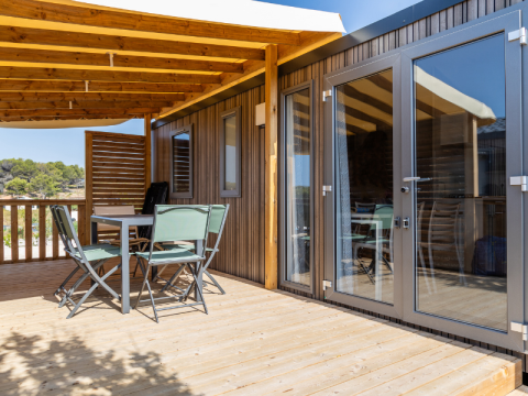 Udendørs terrasse med bord og stole på Premium Mobile Home med bakket beliggenhed på Les Tamaris.